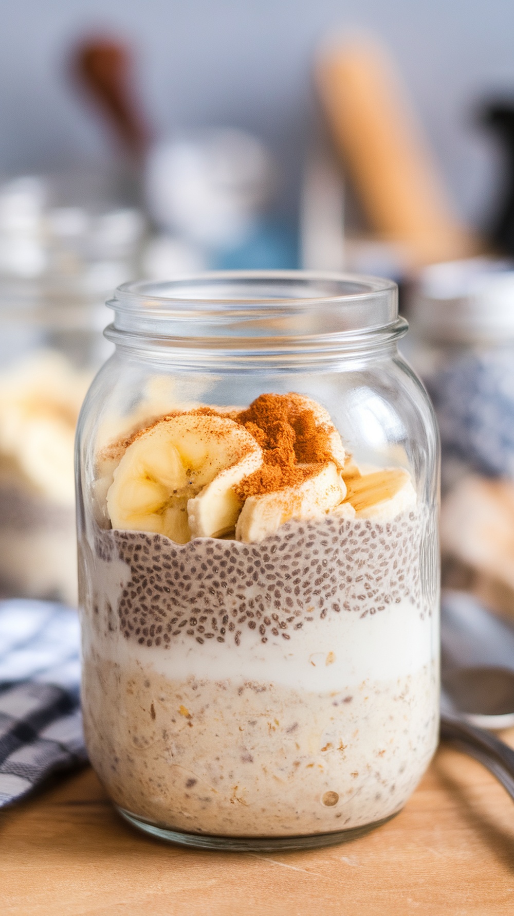 A jar of overnight oats with chia seeds, topped with banana slices and cinnamon.