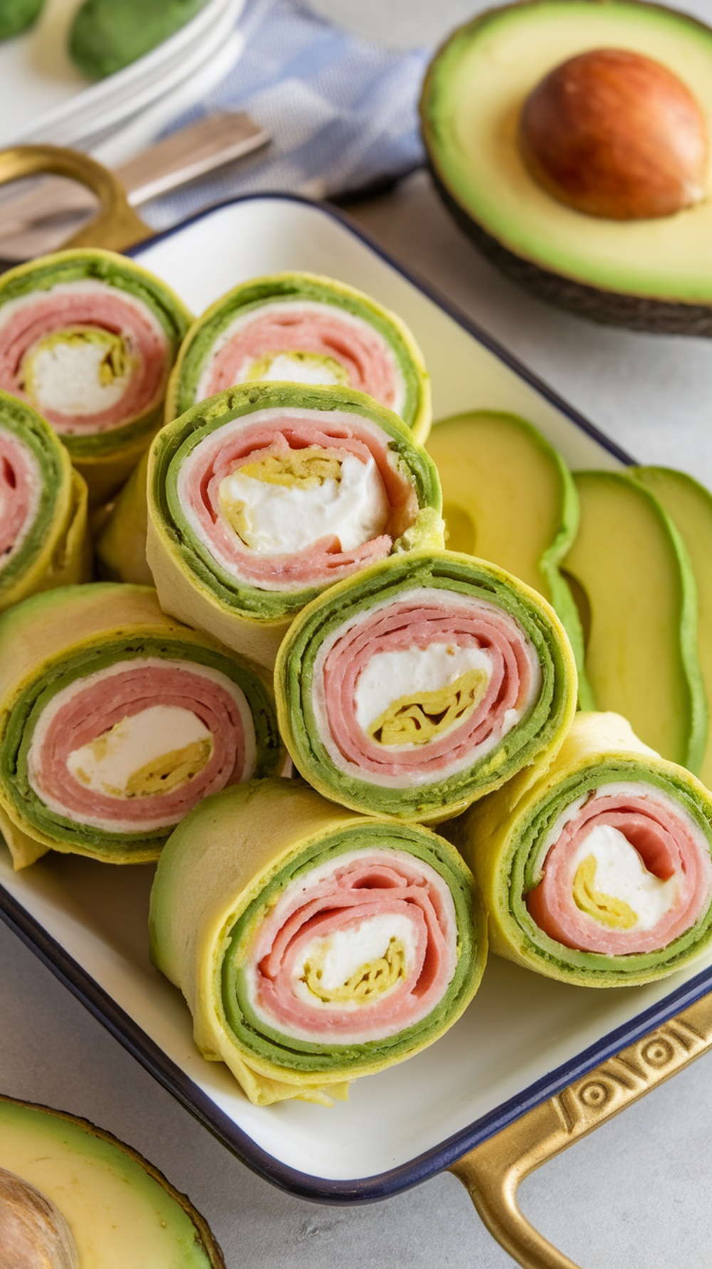 Colorful avocado and ham roll ups arranged on a plate