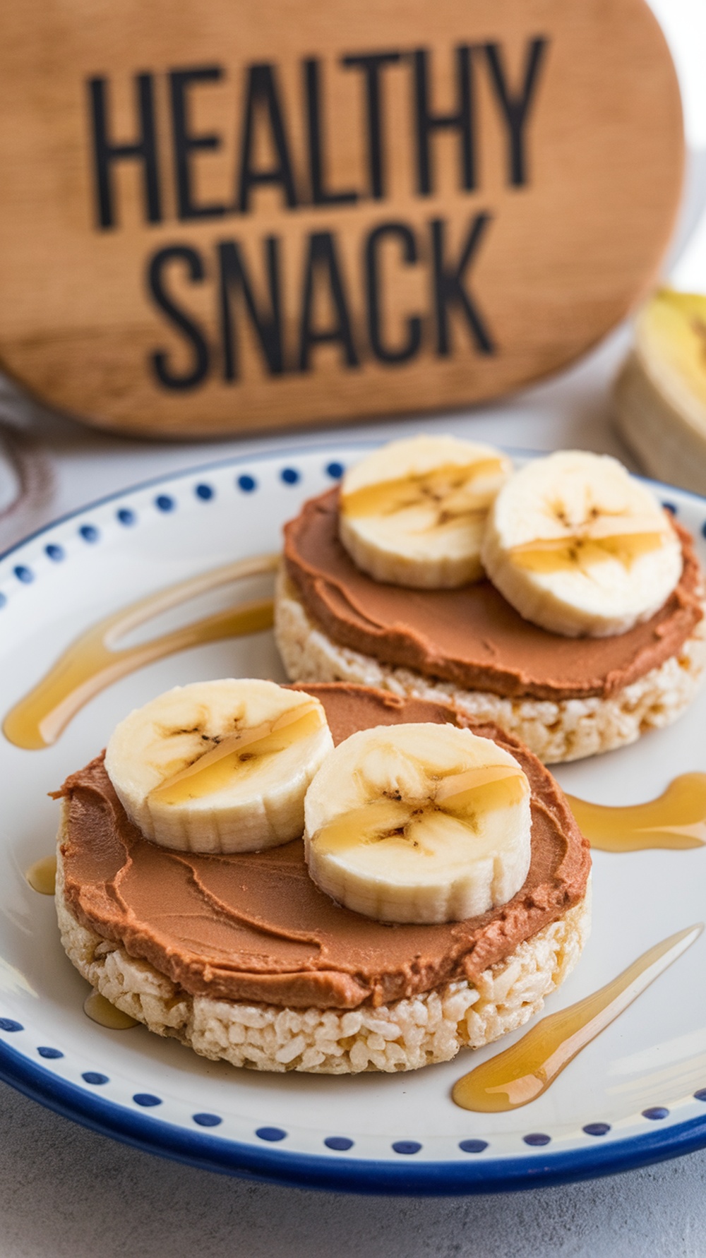Rice cakes topped with nut butter and banana slices, with a sign that says 'Healthy Snack'.